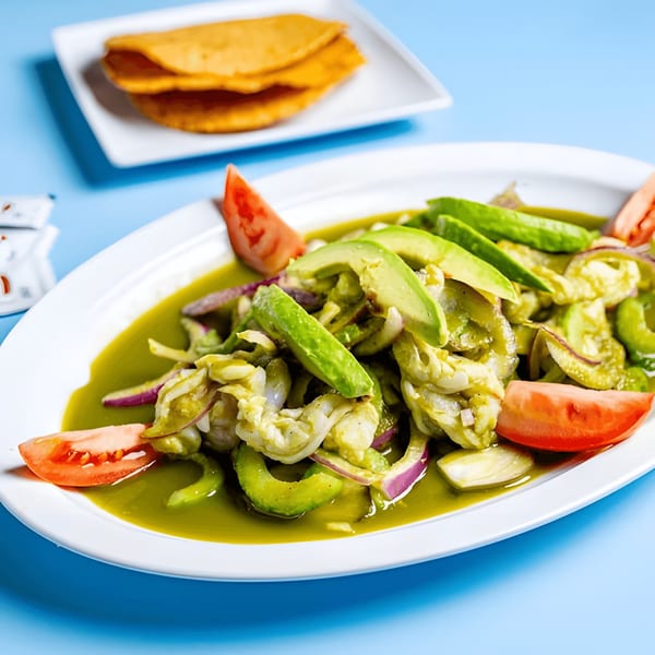 Baja California Tacos' shrimp ceviche with avocado, red onion, and tomato, alongside two quesadillas.