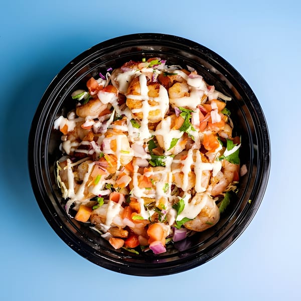 Shrimp taco bowl from Baja California Tacos, topped with pico de gallo and crema.
